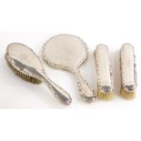 A set of four early 20thC silver backed dressing table items, to include brushes, and a mirror.