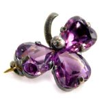 A silver three leaf clover brooch, set with three heart shaped amethysts, on a silver back with stee