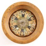 A miniature novelty roulette wheel, with printed register and turned wooden base, 12cm diameter.