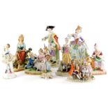 A collection of continental porcelain figurines, to include a figure of a lady beside a table with f