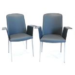 A pair of modern armchairs, upholstered in grey leatherette with metal square tapering legs.