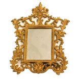 An early 20thC gilt metal rococo design mirror, of shaped form with a pierced scroll and floral out