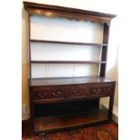 A George II oak dresser, with plate rack, having moulded cornice, shaped apron two shelves to the up