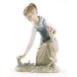 A Lladro figure, of a girl picking flowers on naturalistic base, number I-6A, printed and impressed
