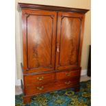 A George III mahogany press cupboard, with dentil moulded cornice over two flame panelled doors, wit