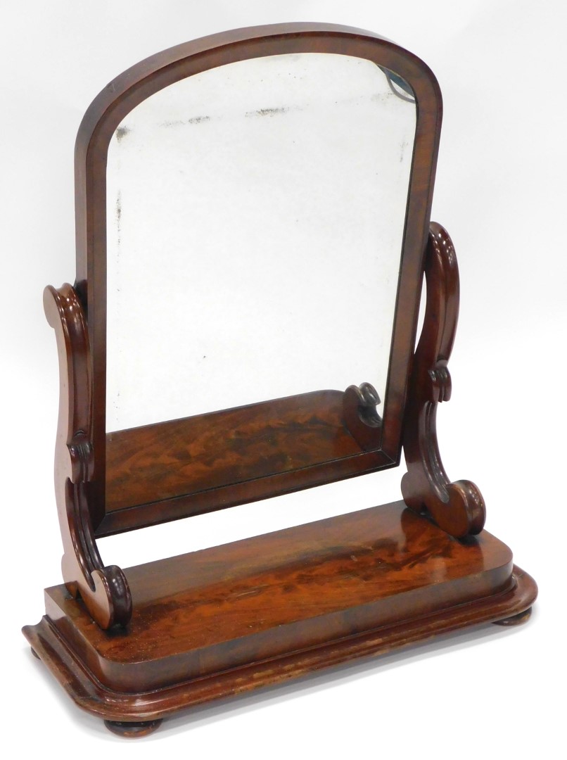 A Victorian figured mahogany dressing table mirror, with an arched plate on scroll carved shaped sup