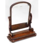 A Victorian figured mahogany dressing table mirror, with an arched plate on scroll carved shaped sup