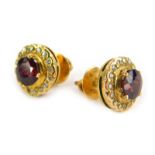 A pair of ruby and diamond earrings, each with round brilliant cut ruby surrounded by tiny diamonds,