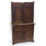 A 19thC French rustic walnut cabinet, the top with a moulded cornice above a heart motif carved to t