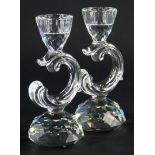 A pair of Swarovski Crystal candlesticks, each with scroll shaped support and faceted tapering base,