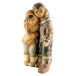 A Lladro brown ceramic figure group, modelled in the form of two embracing Eskimos, printed mark in