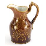 An unusual Rockingham glazed ewer, decorated with gilt roses and flowers and brown glazed ground c18