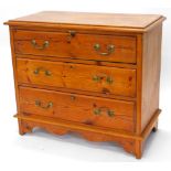 A pine chest of drawers, top with a moulded edge, above three long drawers with brass drop handles o