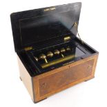 A 19thC Swiss table musical box, with ebonised walnut and cross banded case, the 28cm cylinder strik