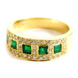 An emerald and diamond set dress ring, the five square cut emeralds, in a rub over yellow metal sett