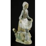 A Lladro porcelain figure group, of a young lady with a rabbit, printed marks in blue to underside,