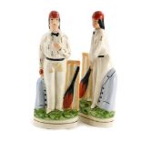 A pair of reproduction Staffordshire figures, each modelled in the form of a cricketer, 25cm high.
