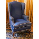 A wingback armchair, with cabriole legs and blue upholstery.