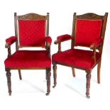 A pair of late 19thC oak open armchairs, each carved with flowers, roundels, etc., with a padded bac