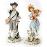 A pair of late Sitzendorf figures of a gardener and his companion, in polychrome enamels and on roco