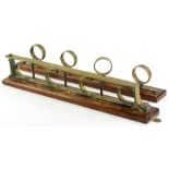 Withdrawn presale by vendor. A two part brass and oak snooker cue stand, with wall mounting, probabl