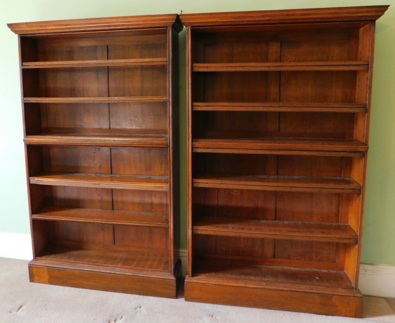 A pair of Edwardian oak open bookcases, with locking bars, 178cm high, 110cm wide.