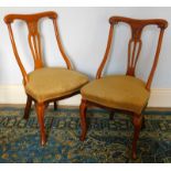 A pair of late Victorian walnut bedroom chairs, with down swept arms and cabriole legs.