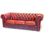 An oxblood red leather Chesterfield, with typical buttoned decoration and studded borders, 189cm wid