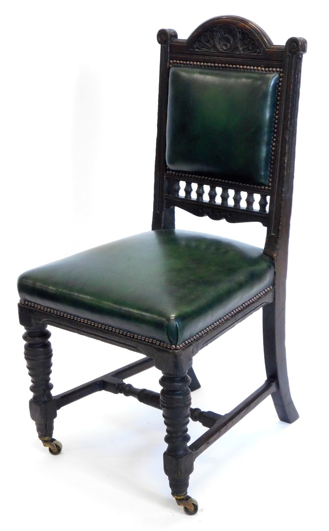 An early 19thC stained oak side chair, with a carved padded back and padded seat, on turned legs wit