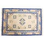 A Chinese rug, with a design of medallions, flowers etc., in mainly blue, on a cream ground with mul