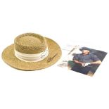 A Greg Norman woven hat, bearing signature, and a photograph.