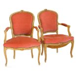A pair of early 20thC French open armchairs, each with a padded back, armrest and seat, upholstered