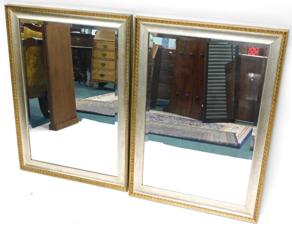 A pair of silvered and gilt wall mirrors, each with a rectangular plate, 107cm high, 75cm wide.