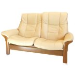 A Stressless Paloma beige leather two seat sofa, with 'walnut' coloured beech frame, 170cm wide.