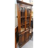 An oak Old Charm standing corner cabinet, with two glazed doors and two panel doors.
