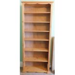 A stripped pine open bookcase, 222cm high, 92cm wide.