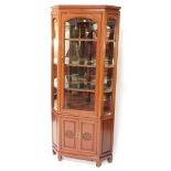 A 20thC Chinese hardwood corner cabinet, the upper section with glazed front and side panels, the po