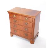 A 20thC chest, the wide crossbanded top raised above two short and three long drawers, each with swa