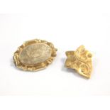 A Victorian gilt metal hair locket brooch, the hinged front foliate engraved, oval reserve monogram