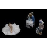 A Lladro porcelain figure of an Eskimo boy and polar bear cub, Nao figure group of a boy and girl se