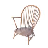 An Ercol dark elm hoop back low armchair, with plain cylindrical spindles, shaped arms and seat on t