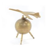 A retro brass desk weight, modelled as a jet plane atop a Sputnik globe, 12.5cm wide.