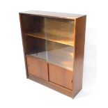 A Herbert E Gibbs autographed vintage 1970's teak bookcase, with glazed doors above double cupboard,