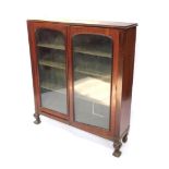 A Victorian mahogany bookcase, with a pair of arched glazed doors revealing plain shelves, raised on