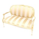 A painted and gilt wood French salon style sofa, with oval backs surmounted by carved ribbons, with