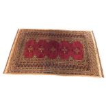A 20thC Persian rug, with an inner geometric floral pattern on red ground, the outer field with a ge