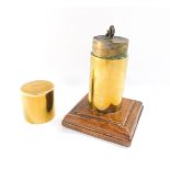 A WWI Trench Art table lighter, in a cylindrical brass casing, on an oak square base, 15.5cm high.