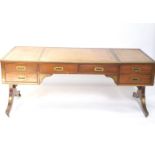 A 20thC campaign style mahogany desk, of rectangular form, with a tooled leather top raised above an