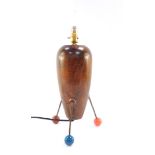 An atomic wooden table lamp, raised on three metal rods and coloured ball feet, 43cm high.