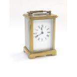 A French brass cased carriage clock, by R & Company Paris, white enamel dial bearing Roman numerals,